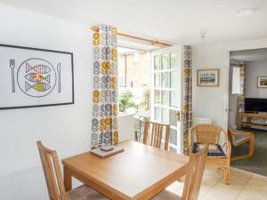 a dining room with a wooden table and chairs at 9 Swallow Court in Herne