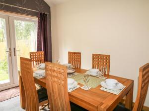 uma sala de jantar com uma mesa de madeira e cadeiras em 79 Corrour Road em Aviemore