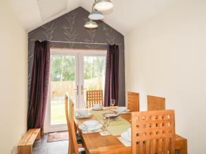 a dining room with a table and chairs and a window at 79 Corrour Road in Aviemore