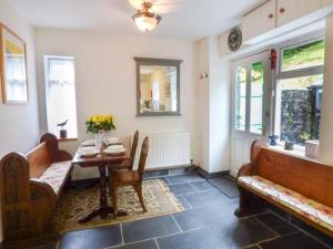 a dining room with a table and a table and chairs at 3 Glanrafon in Llanwddyn