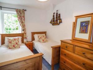 a bedroom with two beds and a dresser at 3 Glanrafon in Llanwddyn