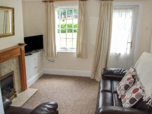 a living room with a couch and a window at 11 Victoria Cottages in Stratford-upon-Avon