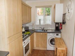 a kitchen with a sink and a washing machine at 11 Victoria Cottages in Stratford-upon-Avon