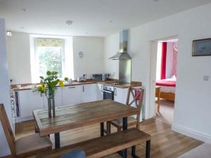 una cocina con una mesa de madera con un jarrón. en Crooklands House 3, en Crooklands