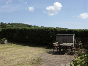 a picnic table and a bench in a yard at Pabo Lodge in Llandudno Junction