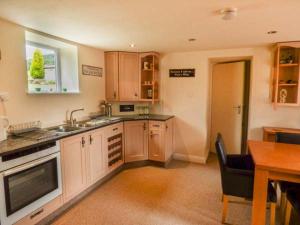 a kitchen with a sink and a stove top oven at Poacher's Rest in Great Rowsley