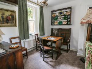 een eetkamer met een tafel en stoelen en een raam bij Sally's Cottage in Carlton