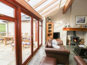 a living room with a couch and a fireplace at Manaros Cottage in Aberdaron