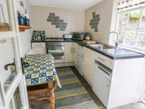 a small kitchen with a sink and a stove at Sally's Cottage in Carleton +16 photos