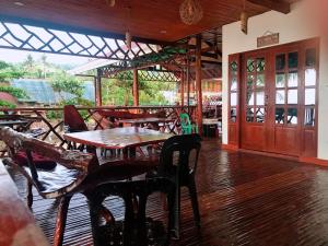 a restaurant with tables and chairs and a wooden floor at Peak View Resort in San Vicente