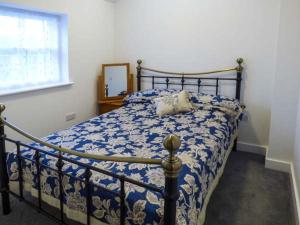 Chelmortonにある2 Primitive Croftのベッドルーム1室(青と白の掛け布団付きのベッド1台付)
