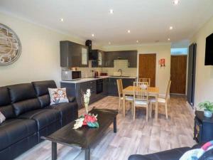 a living room with a couch and a table at Cwm Gran Meadows in Llanharan