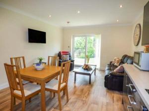 a kitchen and living room with a table and chairs at Cwm Gran Meadows in Llanharan