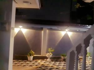 um pátio com vasos de plantas e luzes na parede em 7 guest 3room apartment em Matara