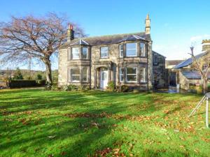 uma grande casa com um grande quintal com relva verde em Old Farm House em Great Rowsley