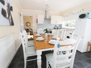 a kitchen and dining room with a wooden table and chairs at Bungalow in Fishguard