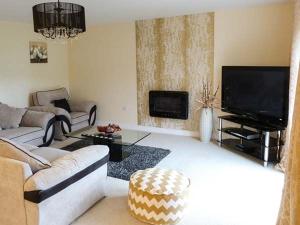 a living room with a couch and a flat screen tv at Pinnacle View in Cowling