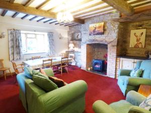 a living room with couches and a stone fireplace at Arllen Fawr in Pen-y-bont-fawr