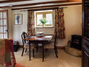 a dining room with a table and chairs and a fireplace at The Old Cider House in Southam