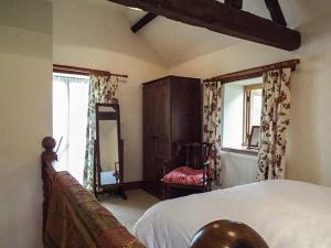 a bedroom with a bed and a dresser and a mirror at The Old Cider House in Southam