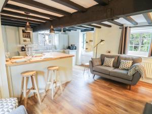 a kitchen and living room with a couch and a table at 4 Masons Court in Stratford-upon-Avon