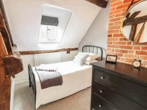 a bedroom with a bed and a mirror and a dresser at 4 Masons Court in Stratford-upon-Avon