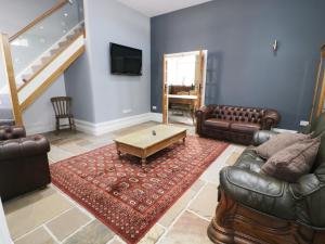 a living room with leather furniture and a coffee table at No 1 Church Cottages in Llanelli