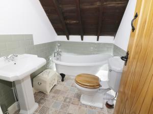 a bathroom with a toilet and a tub and a sink at No 1 Church Cottages in Llanelli +8 photos