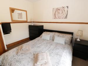 ein Schlafzimmer mit einem Bett mit Handtüchern darauf in der Unterkunft Cae Tanws Bach in Dolgellau