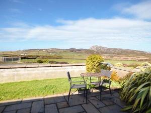 a table and chairs sitting on a patio with a view at Y Wennol in Holyhead