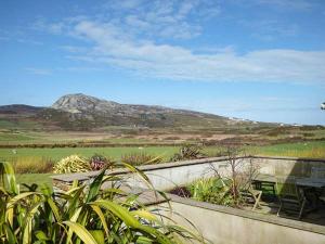 a table and a bench with a mountain in the background at Y Barcud in Holyhead