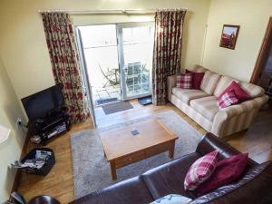 a living room with a couch and a coffee table at Y Barcud in Holyhead