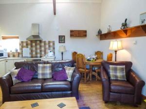 a living room with two leather couches and a table at Y Wylan in Holyhead