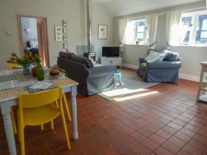 een woonkamer met een bank en een tafel en stoelen bij Goosepond in Wistanstow
