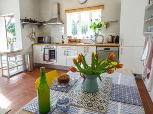 a kitchen with a table with a vase of flowers at Goosepond in Wistanstow +3 photos