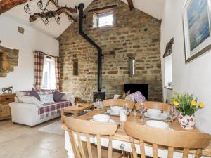 a living room with a table and chairs and a fireplace at Cottage Val in Fylingdales