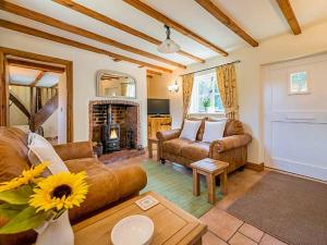 a living room with a couch and a fireplace at Borrowers Cottage in Condover