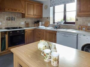 a kitchen with two mugs on a kitchen counter at Fairwater Mill Cottage in Kingsteignton