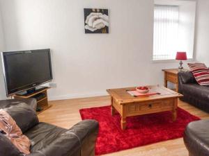 a living room with a couch and a coffee table at Coastal Cottage in Inverallochy