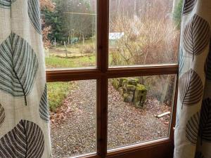 uma janela com vista para um pátio exterior em Lakefield Apartment em Bearnock