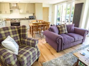 uma sala de estar com dois sofás e uma mesa em Gwdihw em Ifton Heath