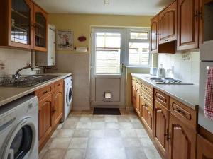 a kitchen with a sink and a washer and dryer at Goldings in Wells +3 photos
