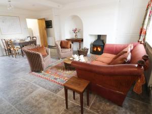 een woonkamer met een bank en een open haard bij Glencoe Cottage in Broadway