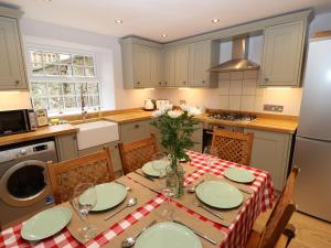 a kitchen with a table with a red and white table cloth at Riber View in Matlock