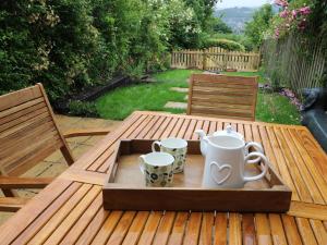 a tray with cups and mugs on a wooden table at Riber View in Matlock