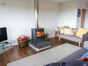 a living room with a wood burning stove in a room at Skipaflotta in Rhiconich