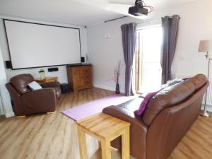 a living room with a couch and a large screen at Penylodge in Builth Wells