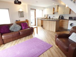 uma sala de estar com dois sofás castanhos e uma cozinha em Penylodge em Builth Wells