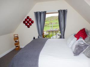 Penylodge في بيلث ويلز: غرفة نوم بسرير ونافذة بها بالونات
