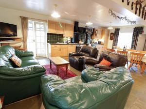 a living room with two leather couches and a kitchen at Tulchan Lodge in Buchanty